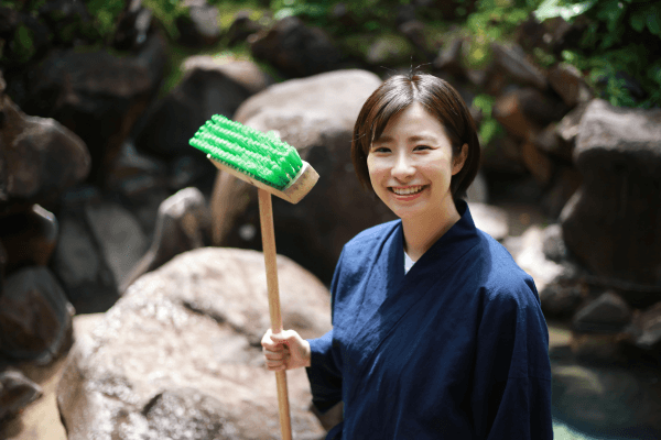 デッキブラシを持つ女性