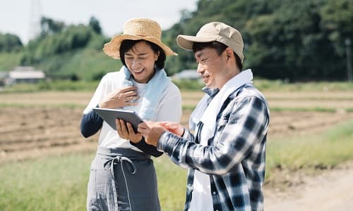 タブレットをみている農家夫婦