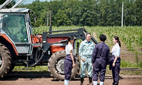 トラクターの前に並ぶ農家